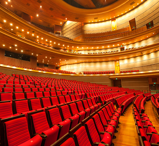 a large auditorium with red seats