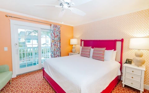 a bedroom with a pink bed and a white ceiling fan