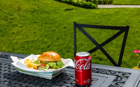 a soda can and a burger on a table