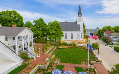 a white building with a flag in the middle of a yard