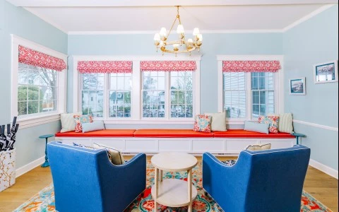 a room with blue chairs and a red and white rug