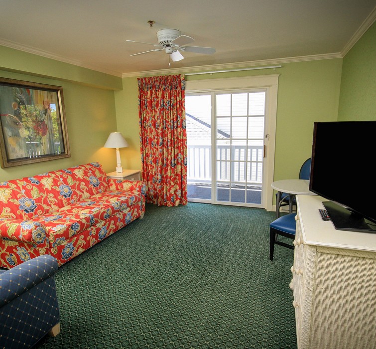 Internal view of a living room with a colorful sofa and a tv