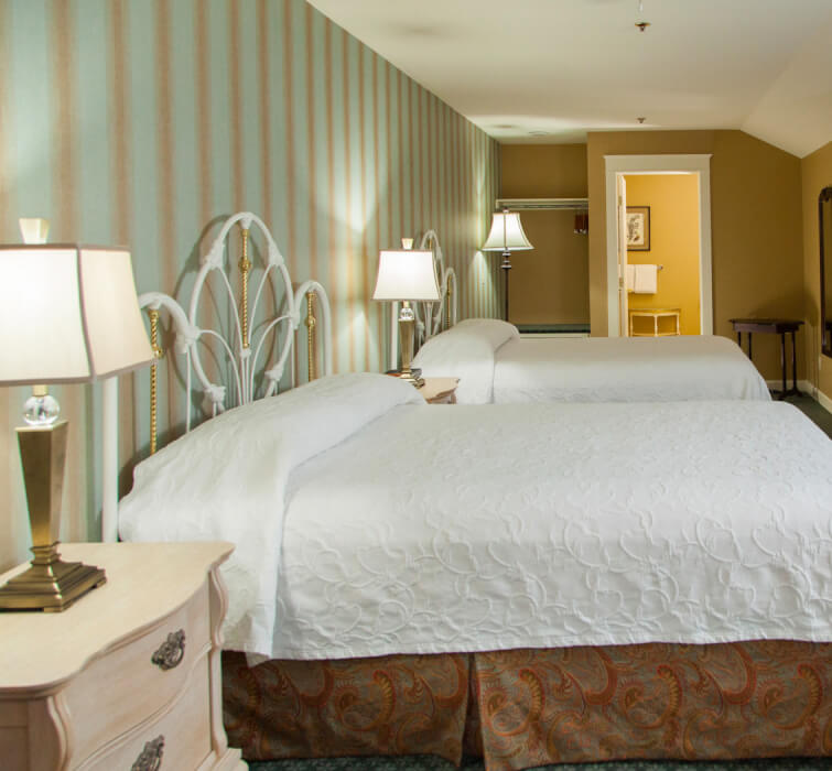 Internal view of two king beds, a tv and two night stands