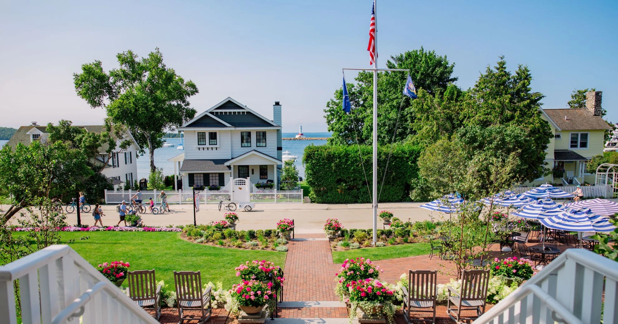 a house with a flag pole and lawn and chairs