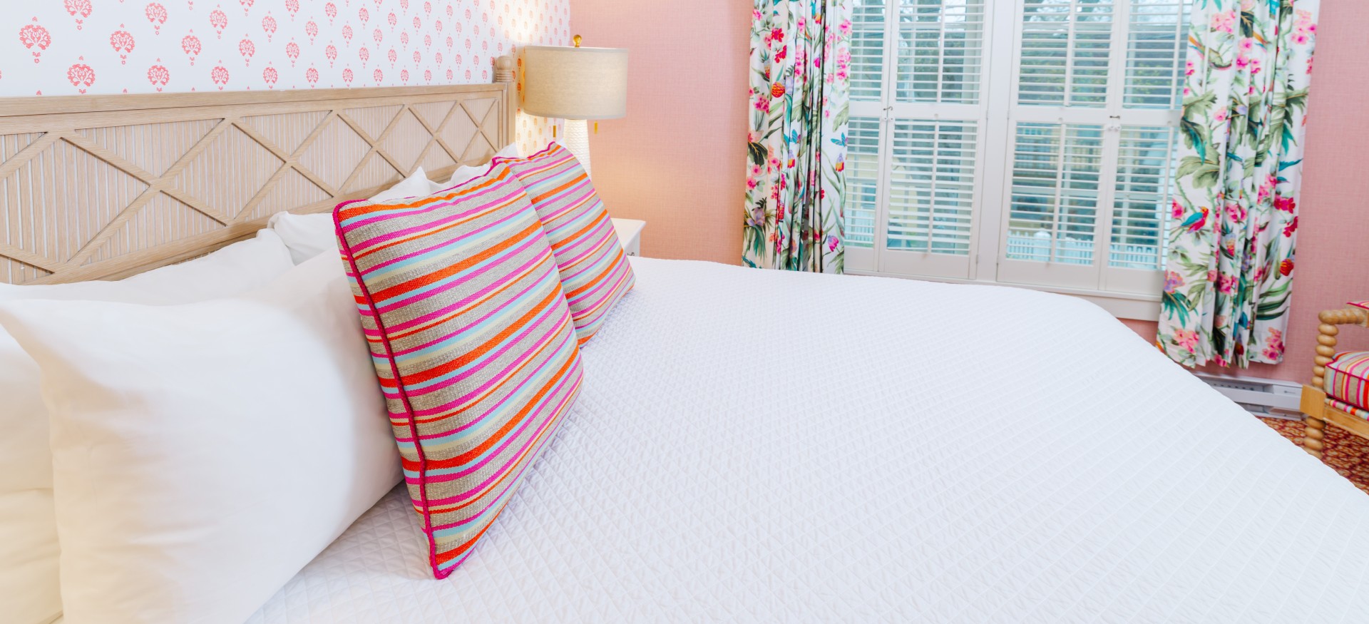 a bed with colorful pillows and a lamp