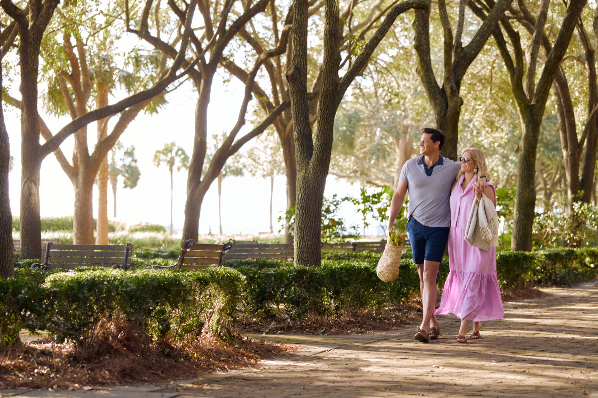a man and woman walking down a path with trees