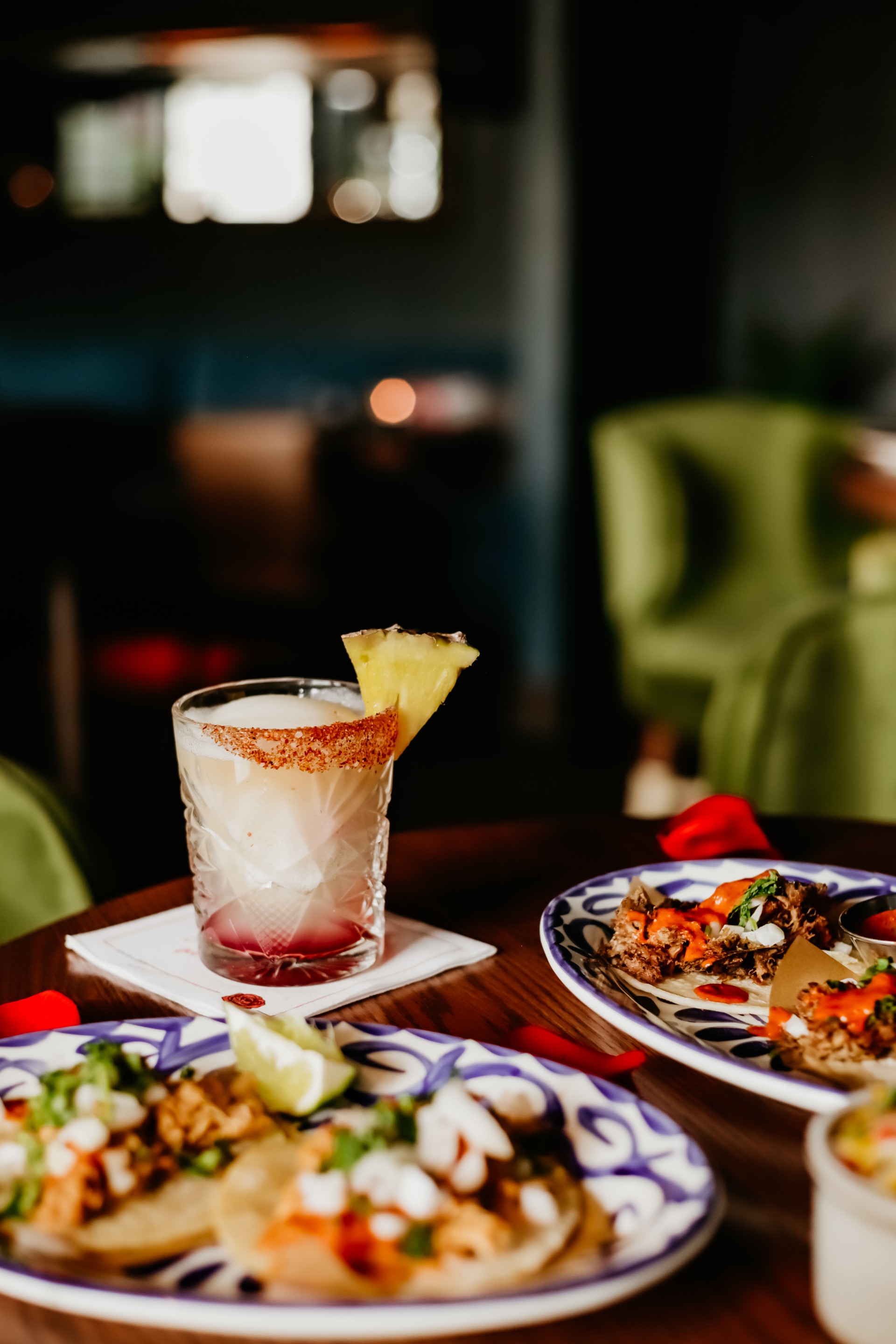 a glass of drink and plates of food on a table