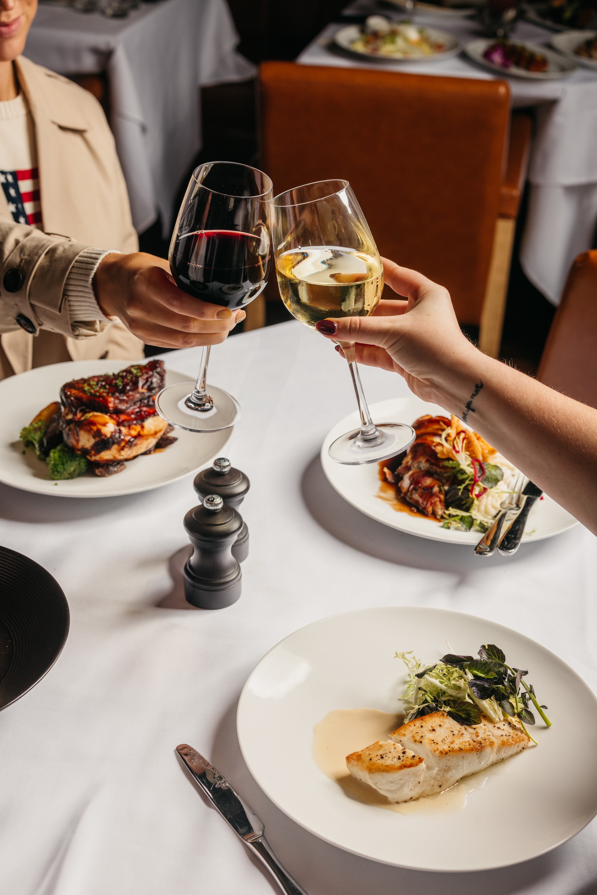 a couple of people holding wine glasses at a table