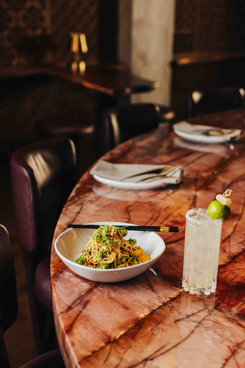 a bowl of noodles and chopsticks on a table