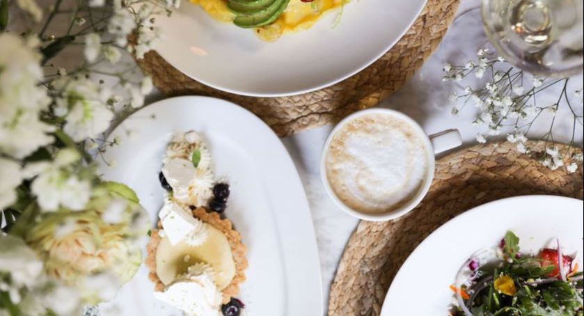 a table with plates of food and a cup of coffee