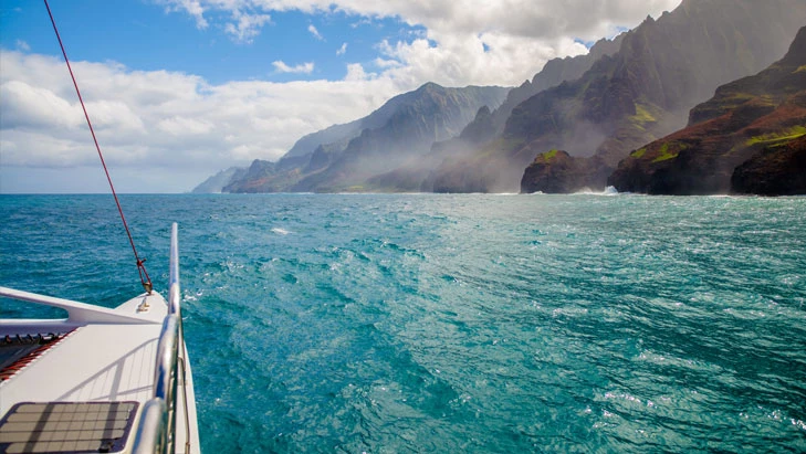 view from a boat of beach with mountains in background
