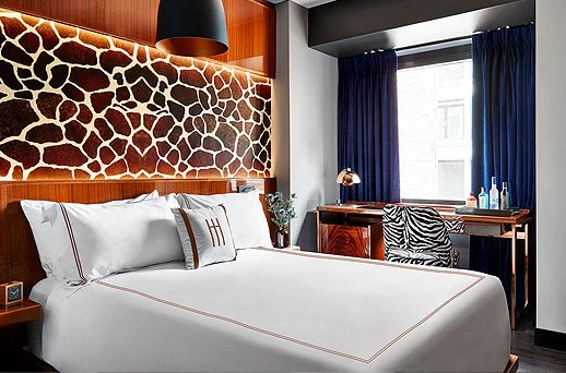A hotel room with a large bed, desk, and window