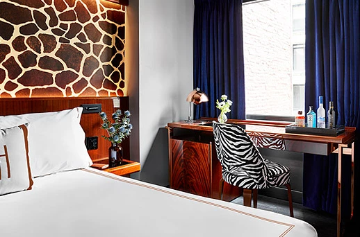 A luxurious hotel room with a king-sized bed, desk, and window