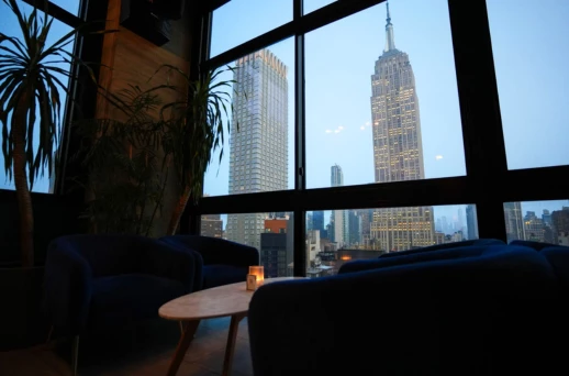 a room with a tall building seen through a window