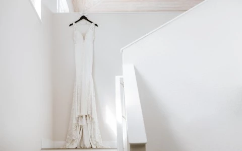 White wedding gown displayed by a staircase.