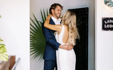Bride and groom posing for a picture outdoors.