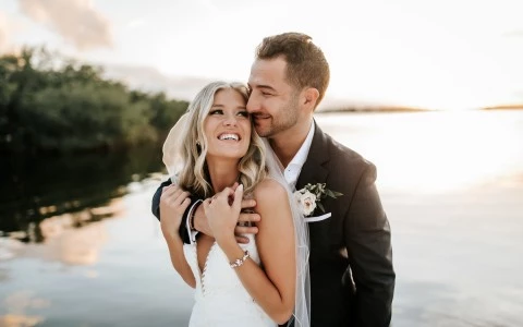 Bride and Groom posing for a picture by the beach.