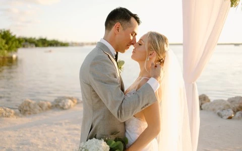 a man and woman kissing on a beach