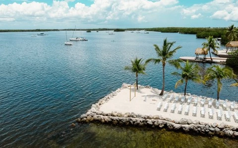 a beach with chairs and tables and a body of water
