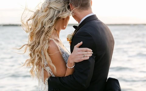 a man and woman kissing on a beach