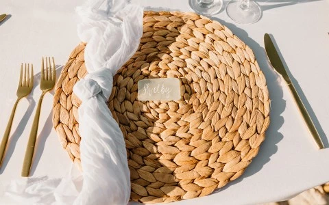 place setting with a woven plate holder and silverware roll up