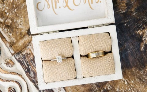 a ring box with the bride and groom's rings sitting on a cushion