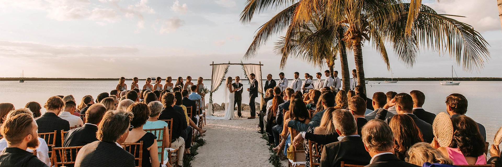 A groom and bride taking their vows during sunset.