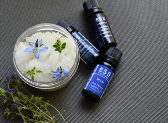a group of small bottles of essential oils and a jar of scrub