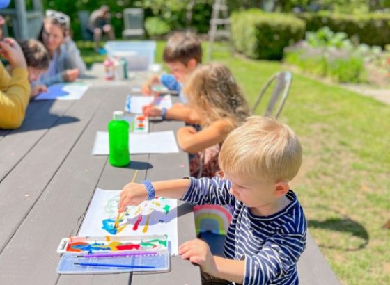 a group of children painting on paper