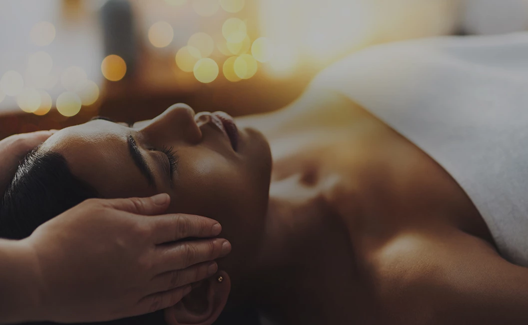 woman receiving a massage by her temples during a facial