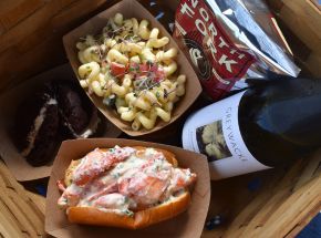 a basket of food and a bottle of wine