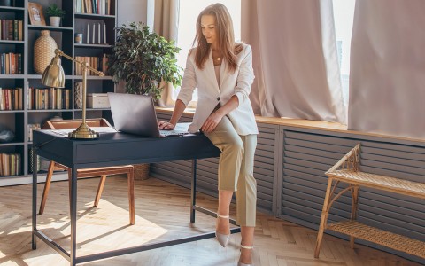 woman sitting in his desk watching his computer
