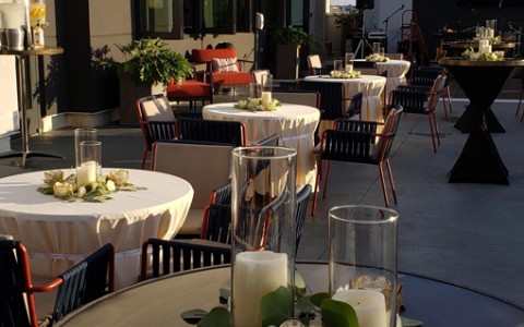 table on a terrace showing more tables with wedding decor