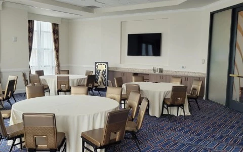 room with three tables and a tv on the wall6