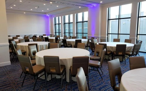 meeting room with multiple rounded tables and chairs around 4