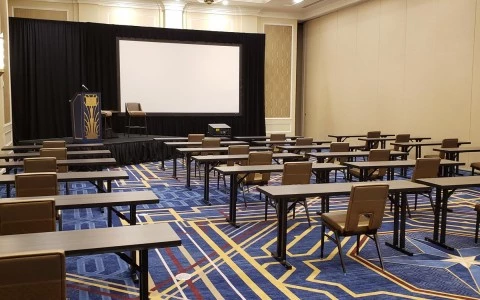 meeting room with some desks and stage and a screen8