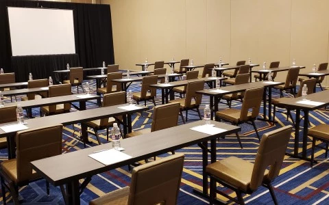 room with six rows of desks and a stage 15