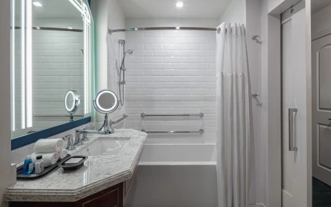 bathroom with a bathtub with white curtains and a side sink 20