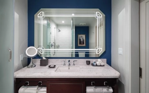 front view of a bathroom with a wall mirror and a sink reflecting a shower 19