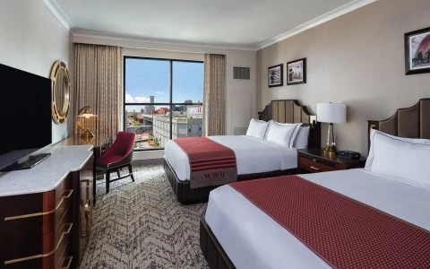 side view of a bedroom with two double beds and a city view 17