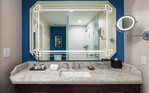 front view of a bathroom with a wall mirror and a sink reflecting a shower 13
