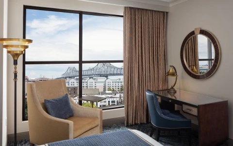 bedroom with a desk and a rounded mirror with a chair and amazing city view 9