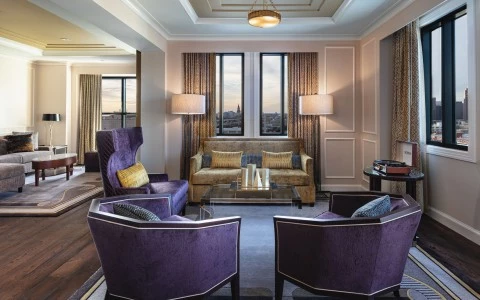 living room with three purple chairs and a gold sofa with two side lamps 7