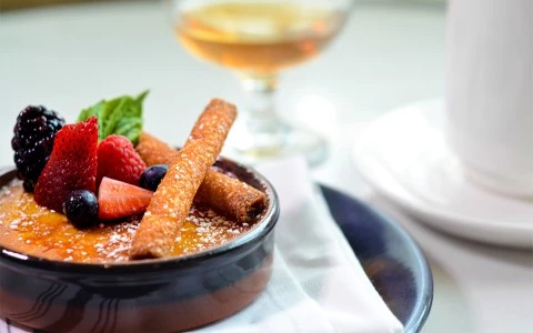 creme brûlée topped with fresh berries and rolled pastries13