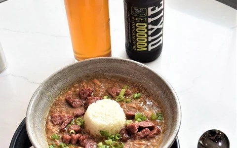 bowl of gumbo with white rice and a glass of beer15