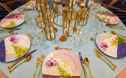 close up of a wedding table showing dishes and decor candles on it 16