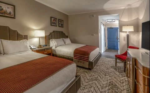 a room with two beds and a red chair