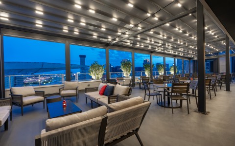 a room with tables and chairs and a view of a city