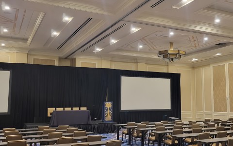 a room with a large screen and chairs