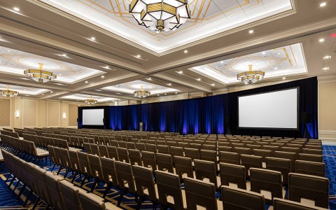 a room with a large screen and chairs